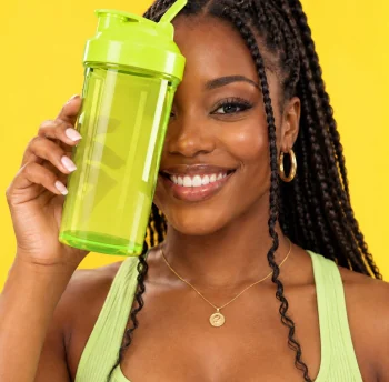 Mulher sorrindo com coqueteleira verde